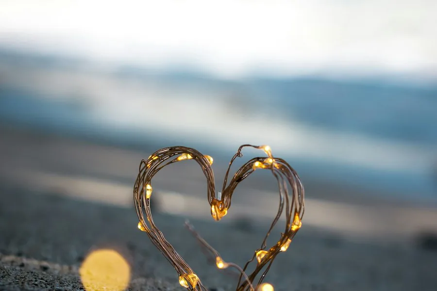 Heart shape made of lights on a sandy beach (illustrative stock photo)