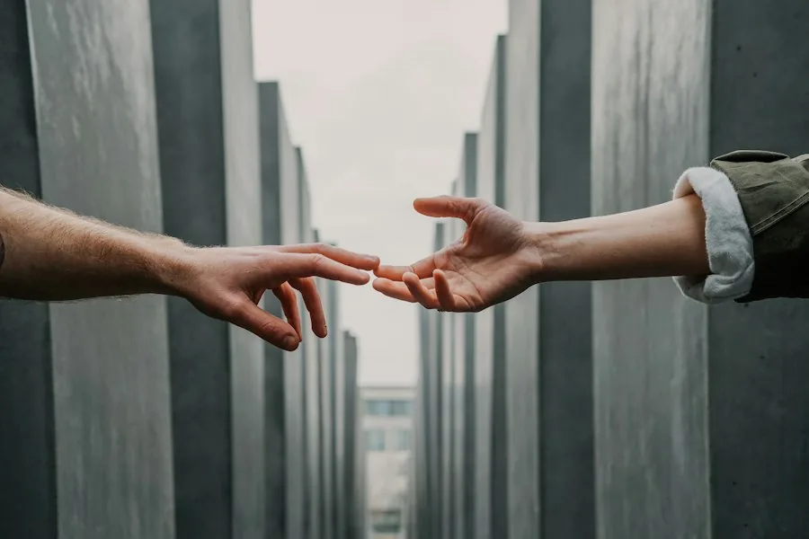 Two hands reaching toward each other (illustrative stock photo)