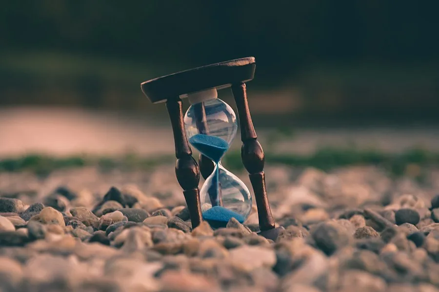 Hourglass resting on pebbles (illustrative stock photo)