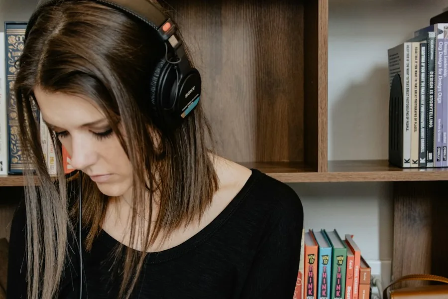 Woman wearing headphones while writing in a notebook (illustrative stock photo)